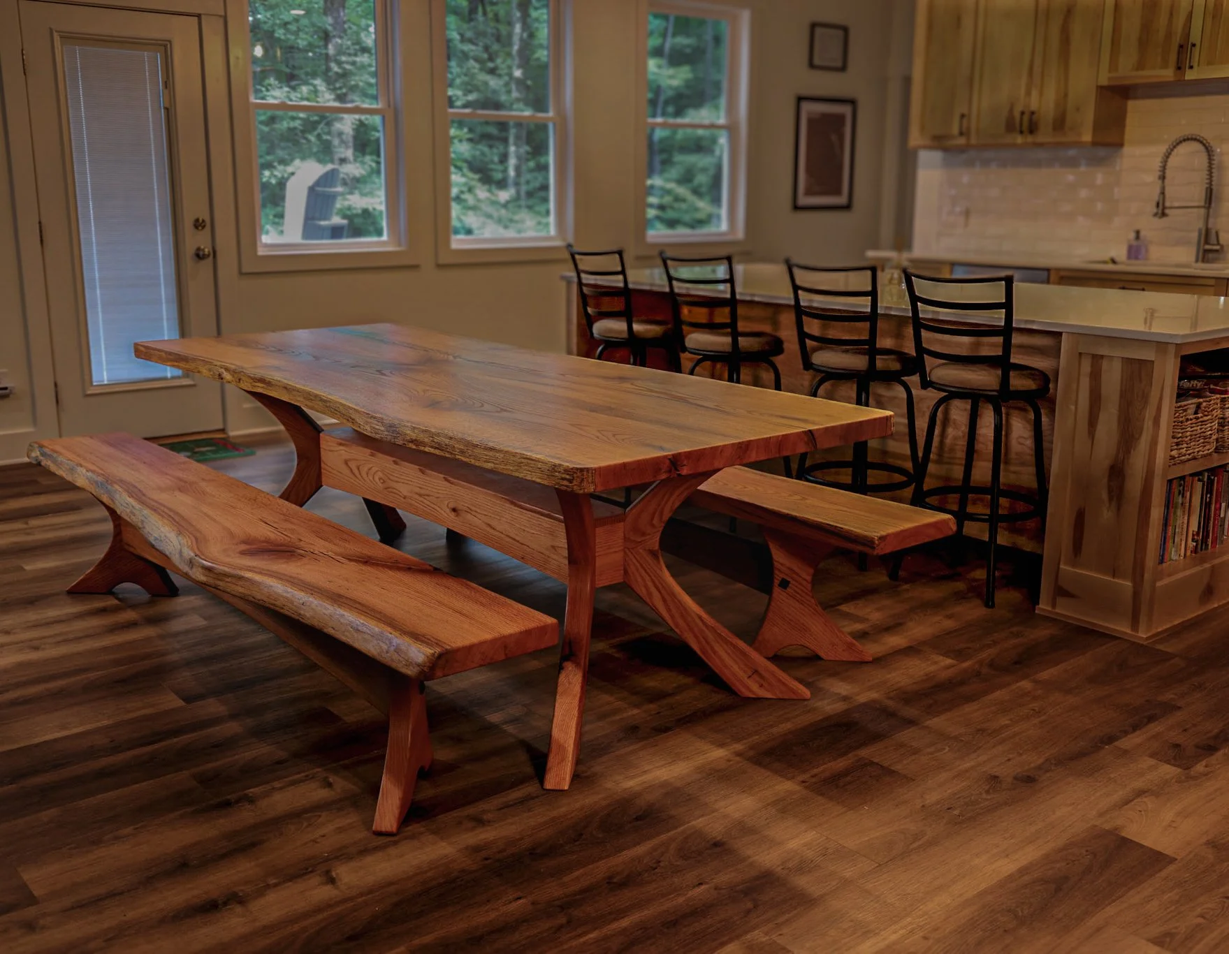 Dining room with a wooden table, bench, black chairs, a chandelier, a rug, and large windows with natural light.