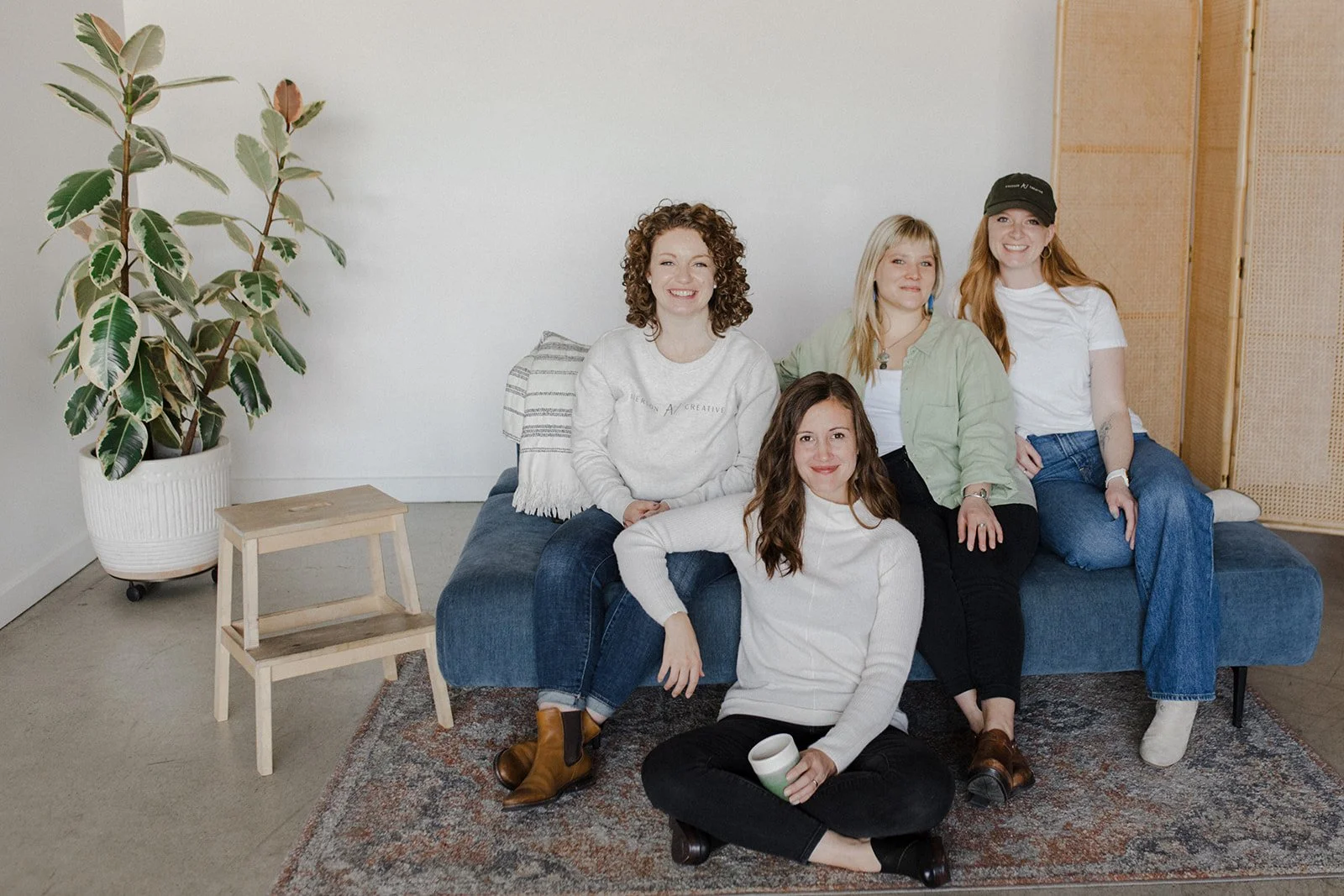 Averson Creative team sitting on a couch together posing for a  brand photoshoot