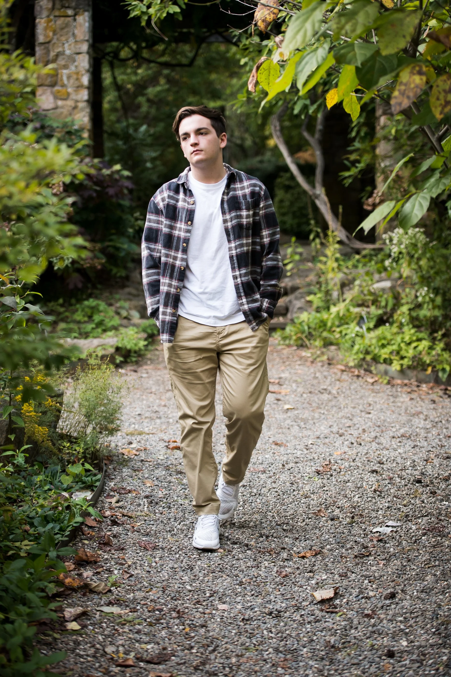  high school senior portraits of male graduate walking outdoors at a park in New jersey 