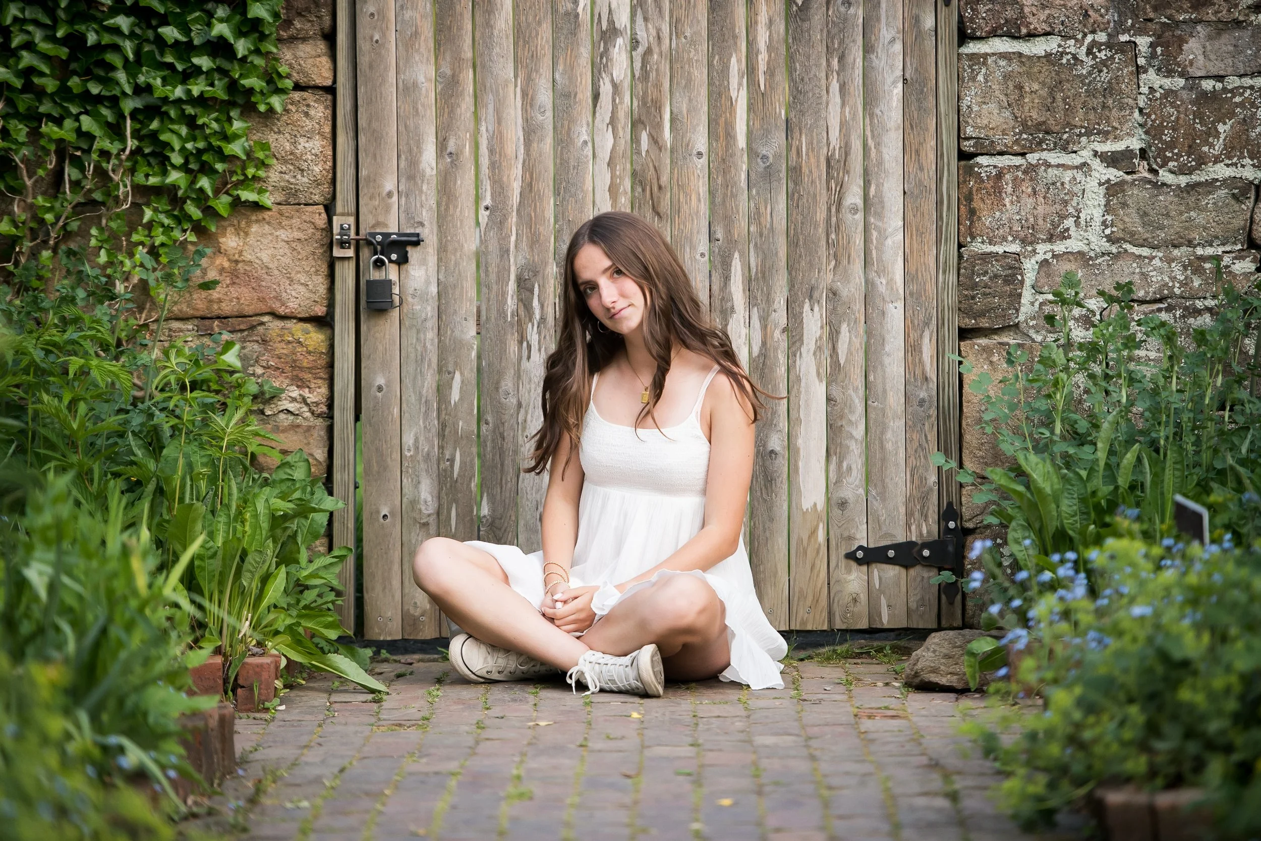  creative senior photo sitting against a wooden doors outdoors 