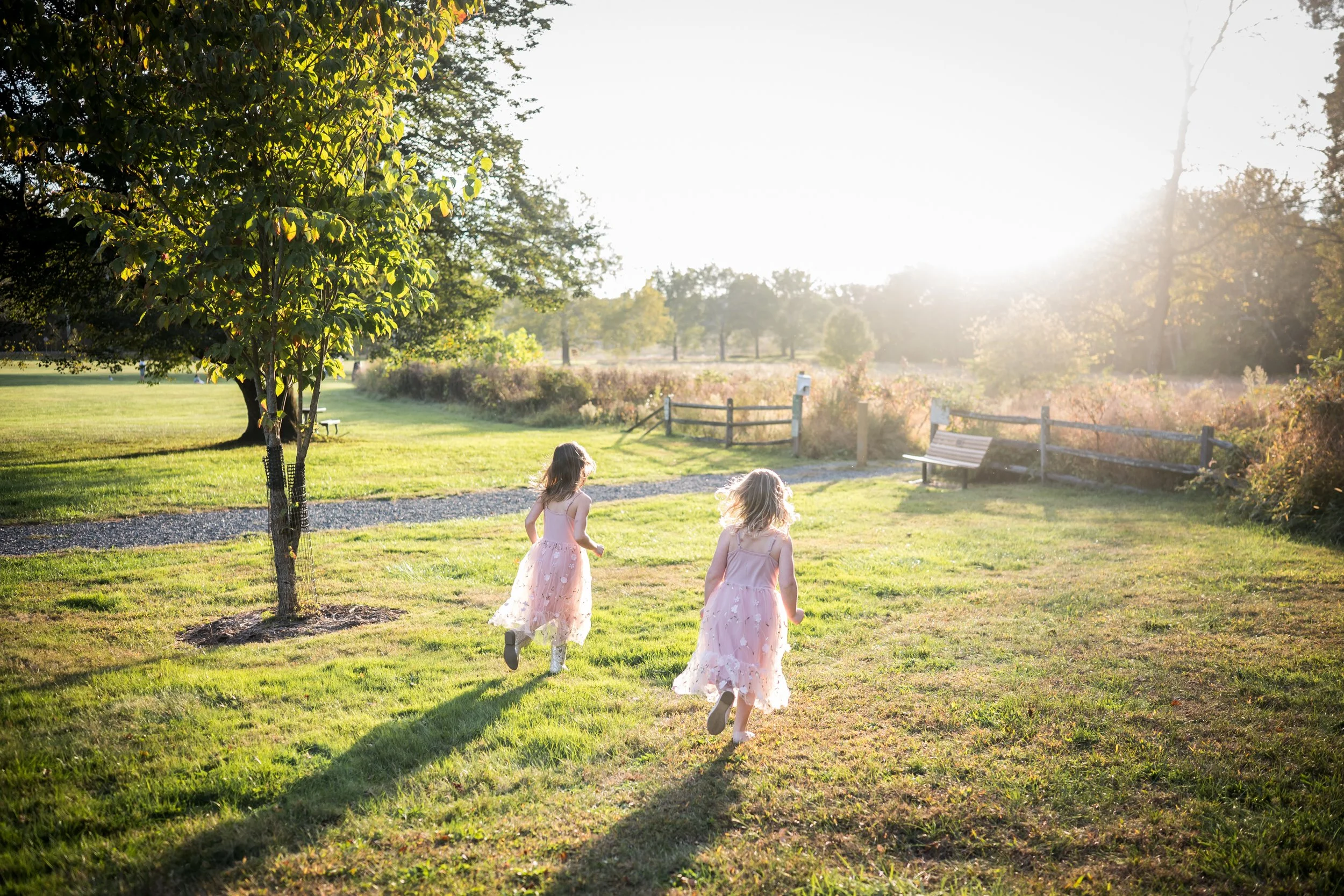 two girls running on a field having fun during their family photoshoot