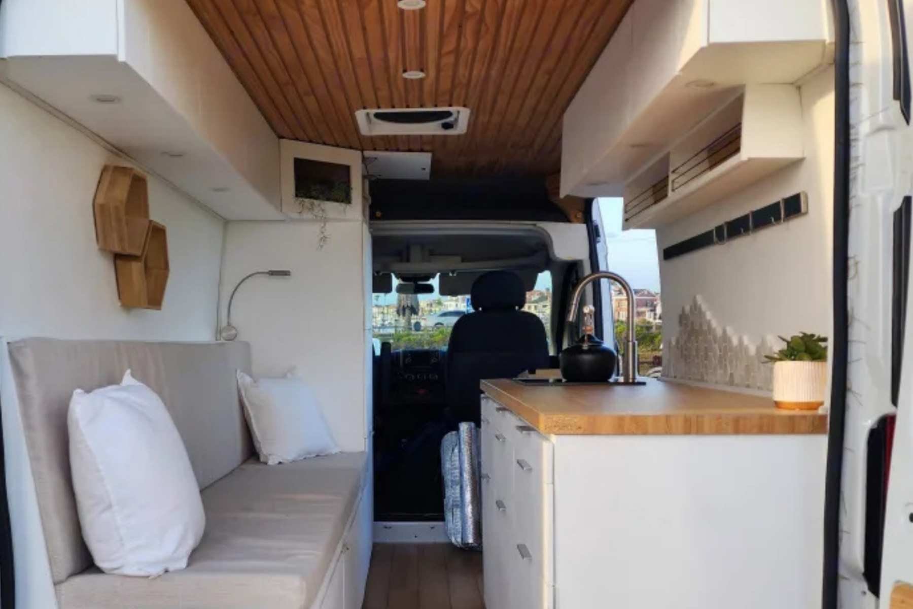 Best budget camper van in Massachusetts with modern interior, sofa bed, kitchenette, and wood ceiling.