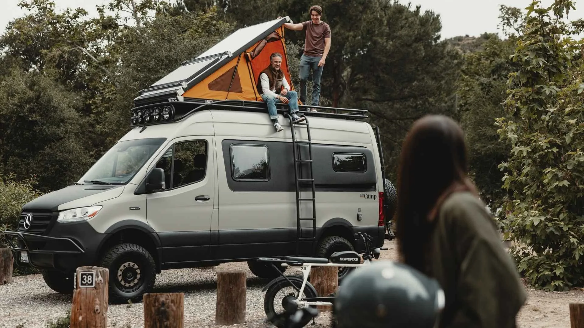 Image a father and son on the roof of a luxury mercedes sprinter van rental in California.