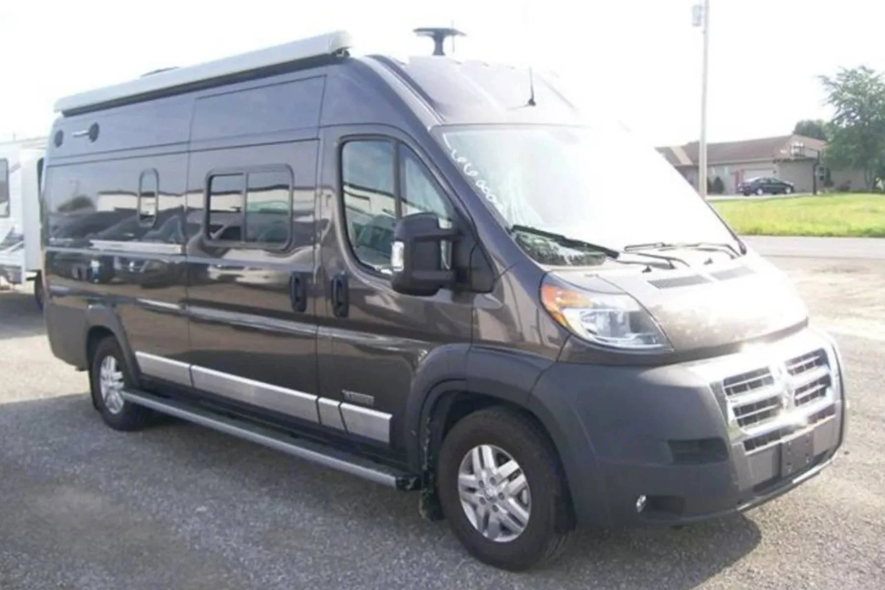 Top rated Winnebago camper van rental in South Carolina, featuring a gray Class B RV parked in an open lot with a high roof, side windows, and built-in awning for comfortable road trips.