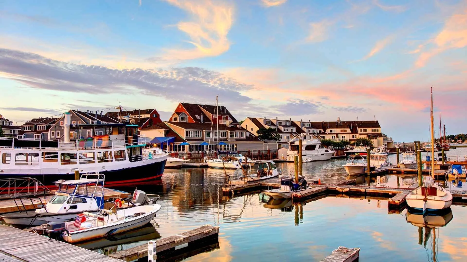 Scenic coastal harbor in Massachusetts with boats and waterfront homes, perfect inspiration for a camper van road trip.