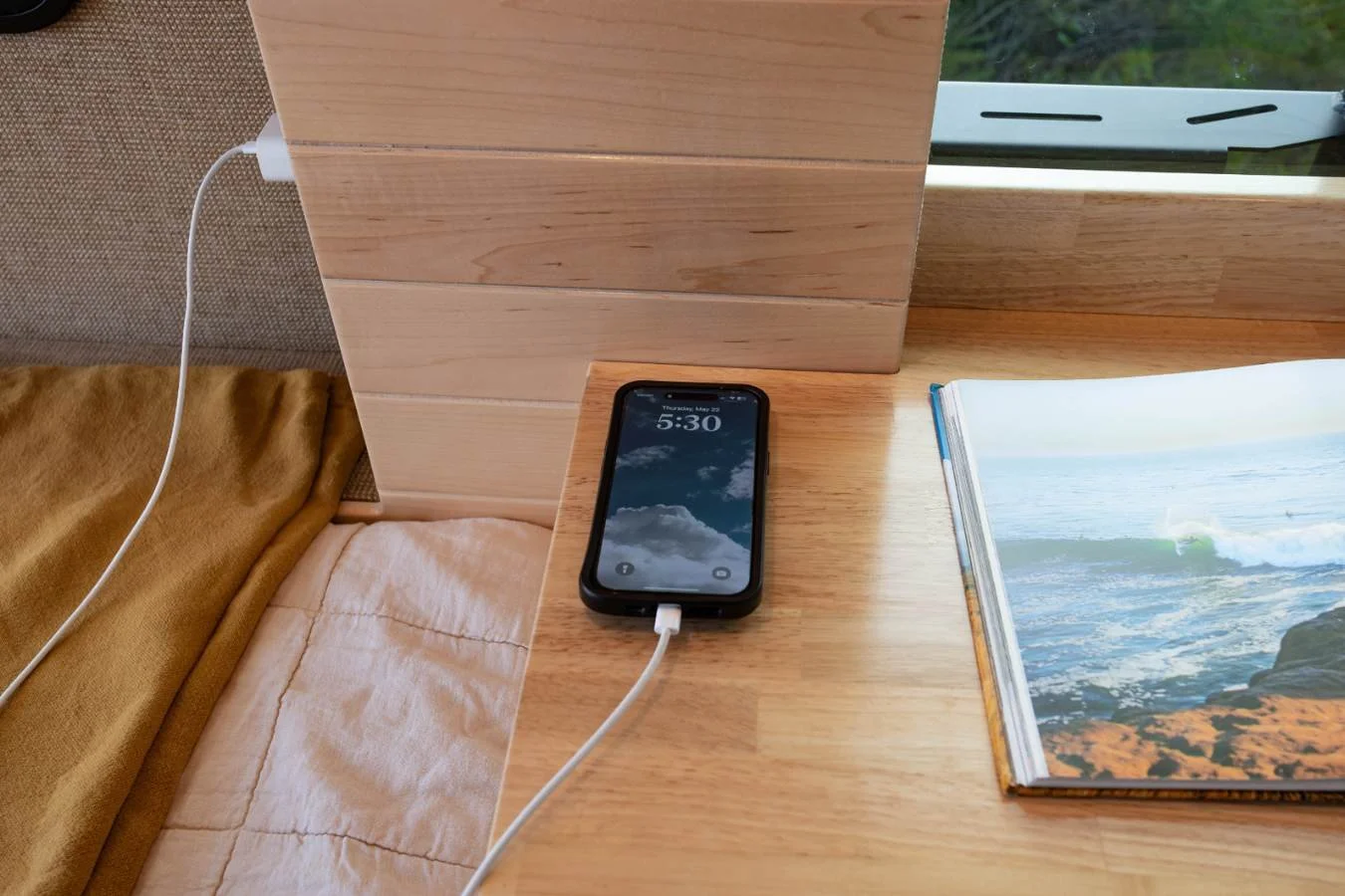 USB charging station next to rear bed inside luxury Sprinter camper van