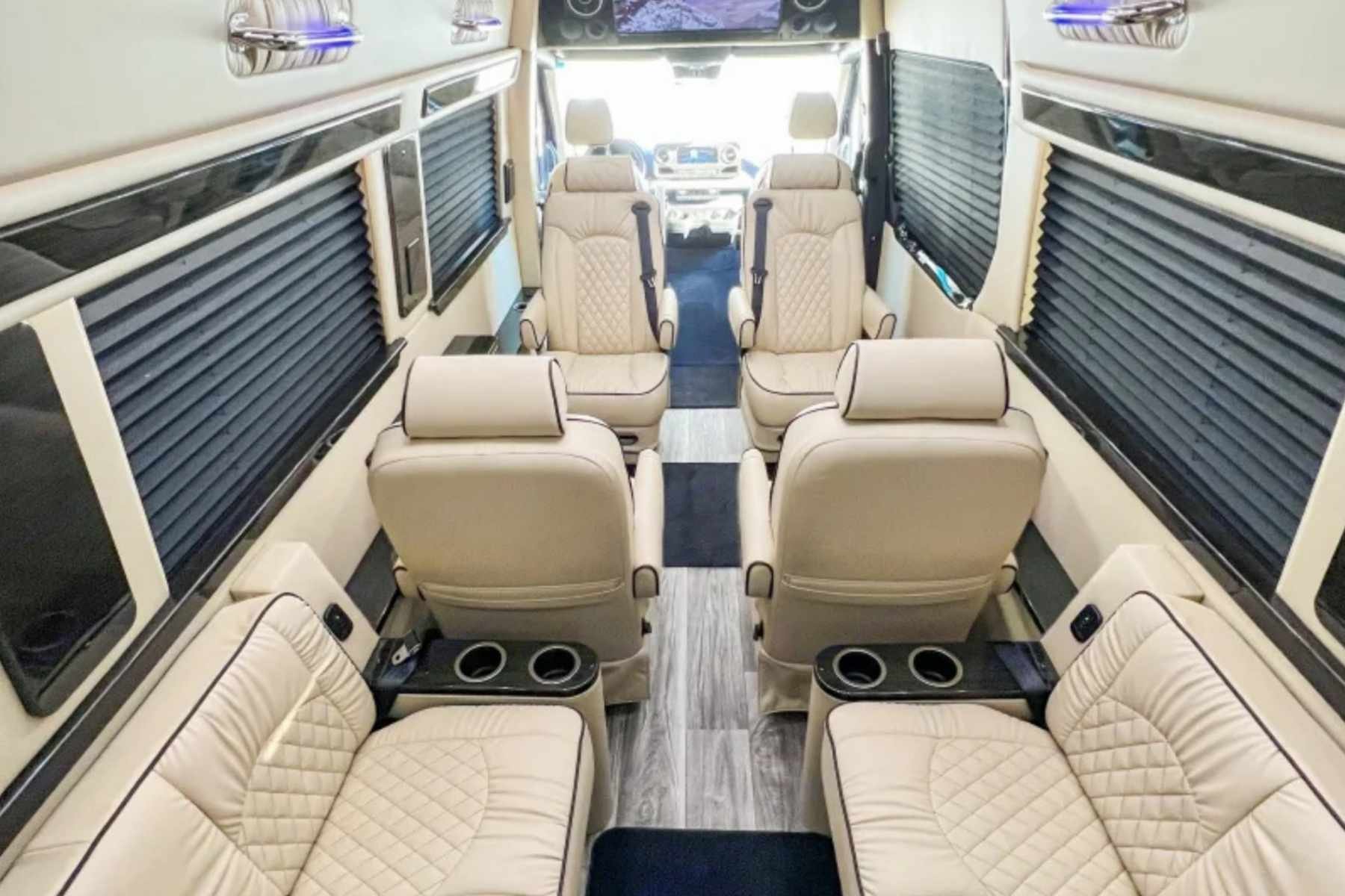 Best luxury passenger van rental in South Carolina featuring a premium interior with quilted leather captain’s chairs, rear bench seating, window shades, and built-in cupholders for a comfortable group ride.