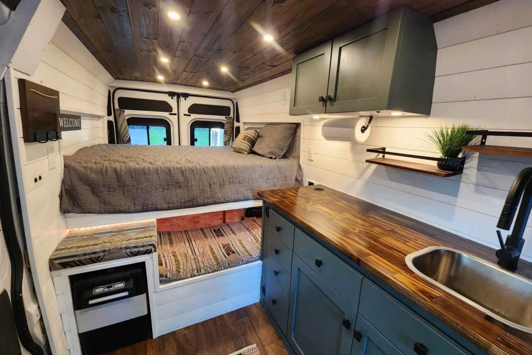 Budget conversion van interior with bed, kitchenette, and compact living space