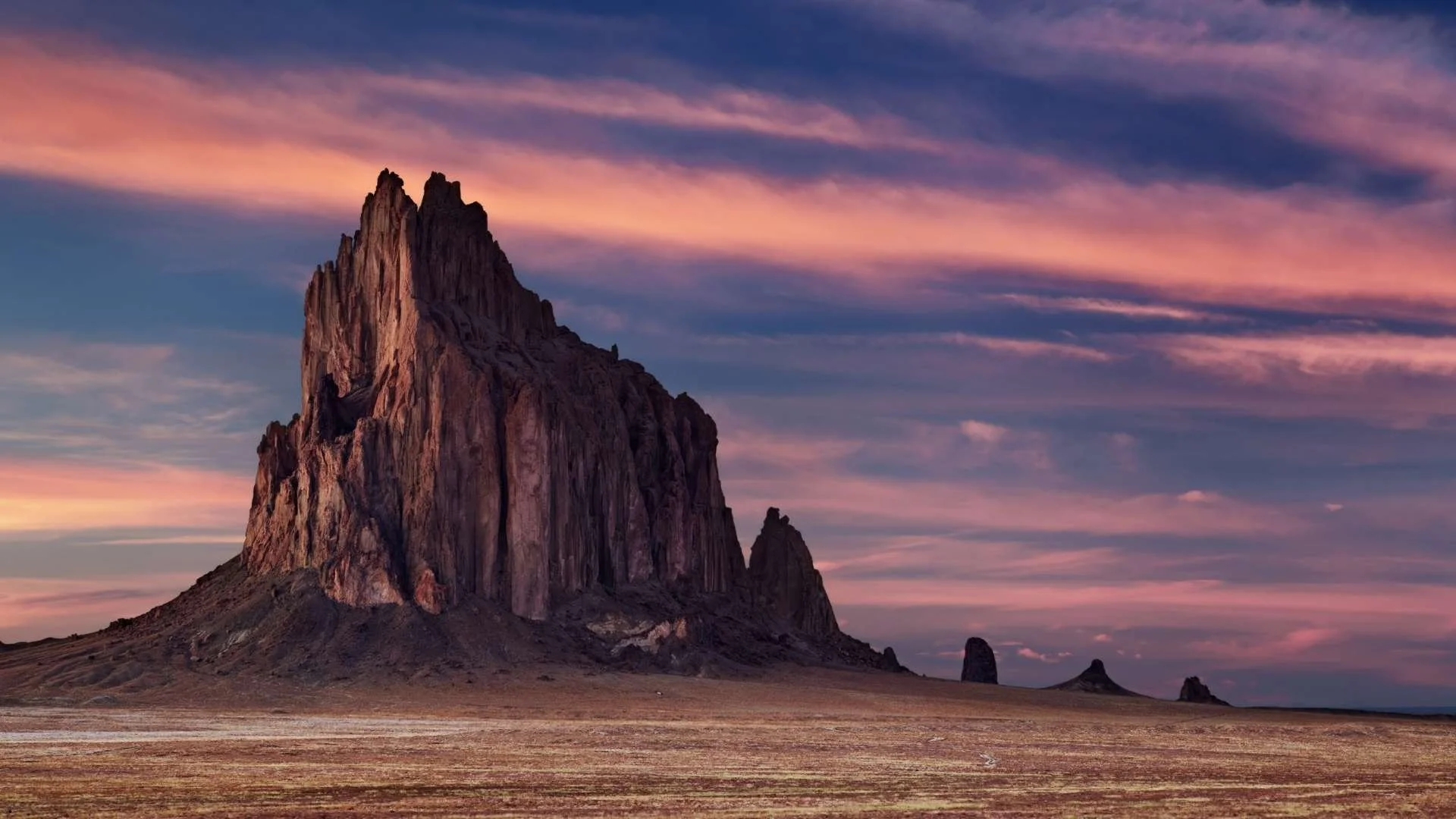 Shiprock rock formation in New Mexico at sunset with dramatic desert landscape and colorful sky