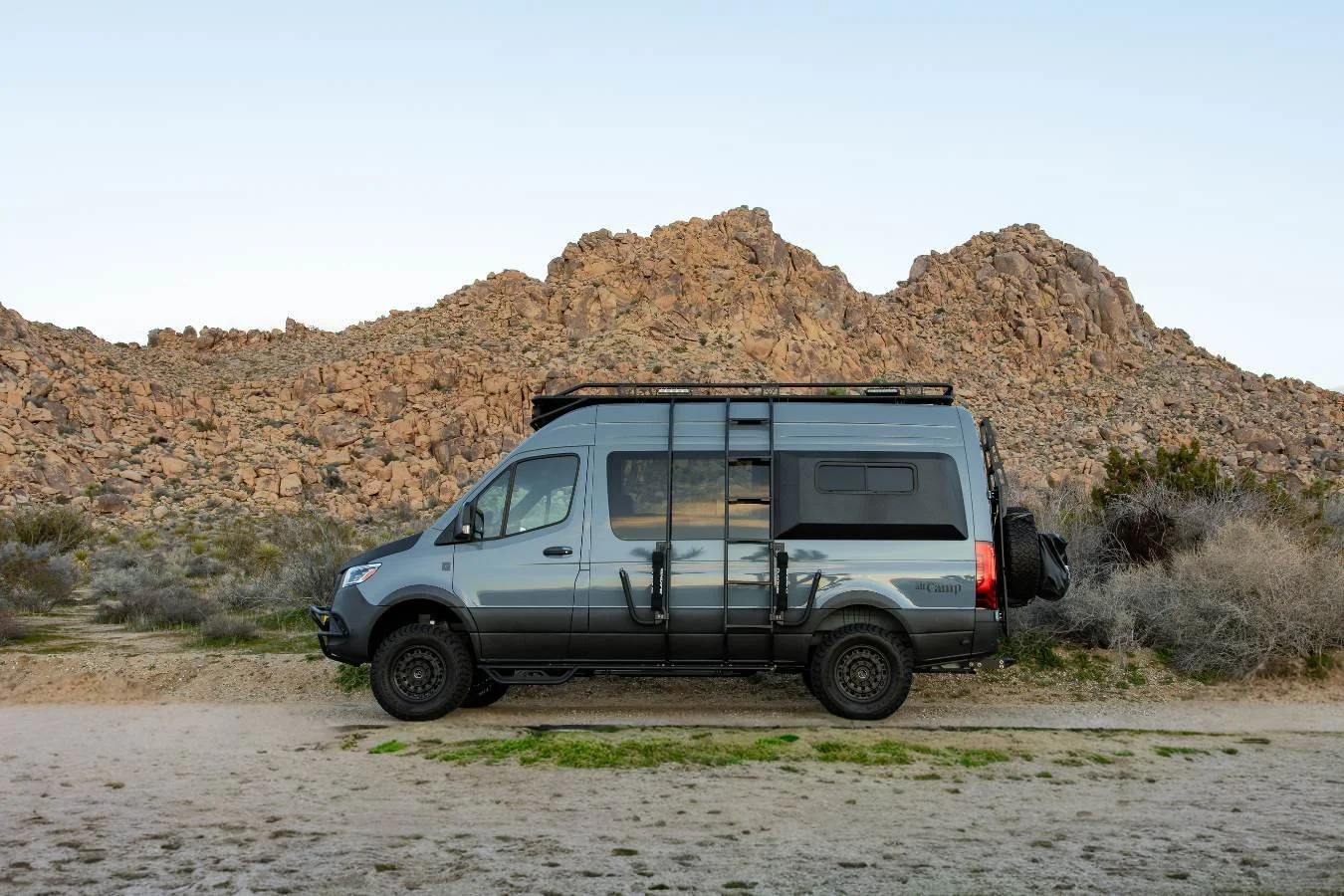 Luxury Mercedes Sprinter camper van parked in Joshua Tree landscape for off-grid road trips.