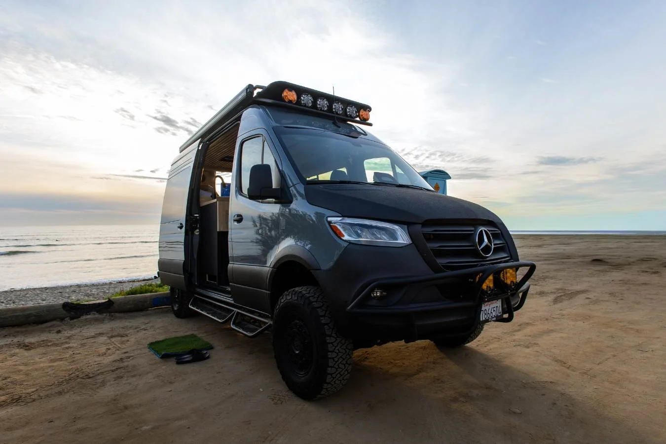 Luxury Mercedes Sprinter camper van parked at San Onofre State Beach at sunset