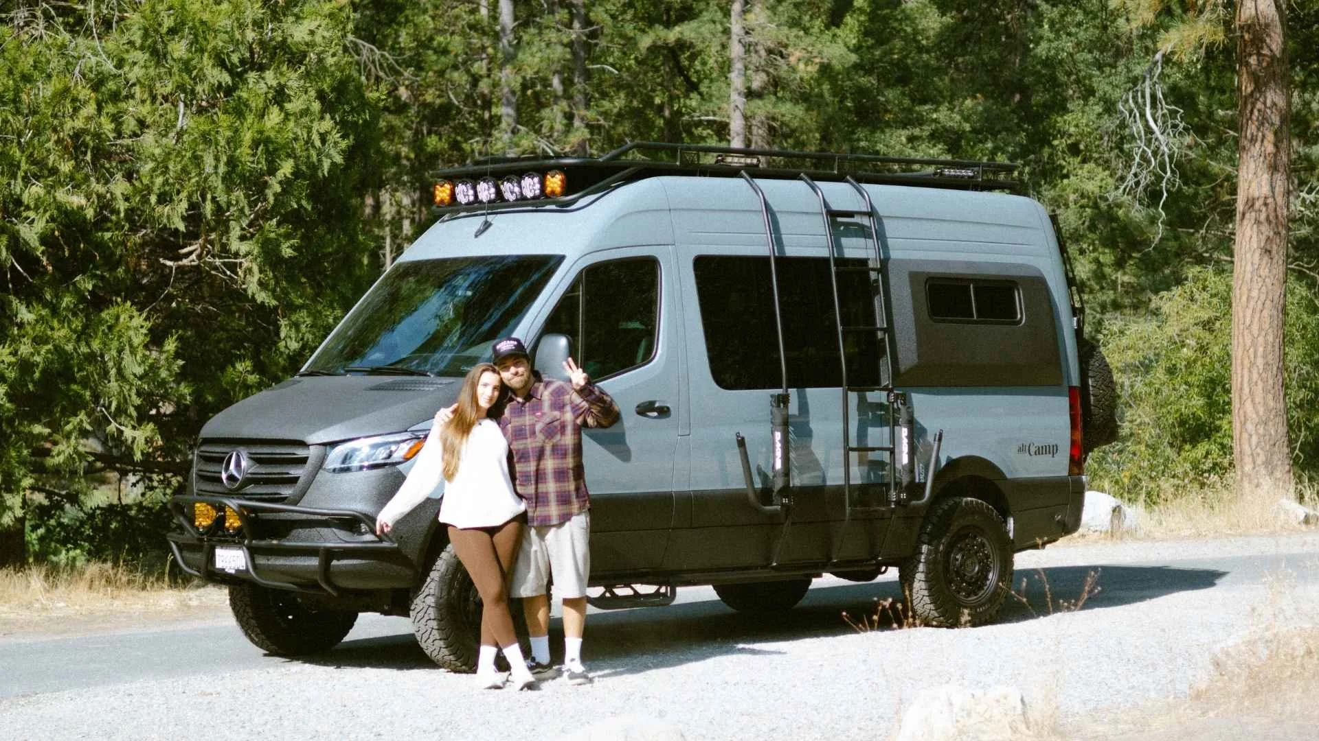 two people standing in front of a luxury sprinter camper van from altcamps signature collection