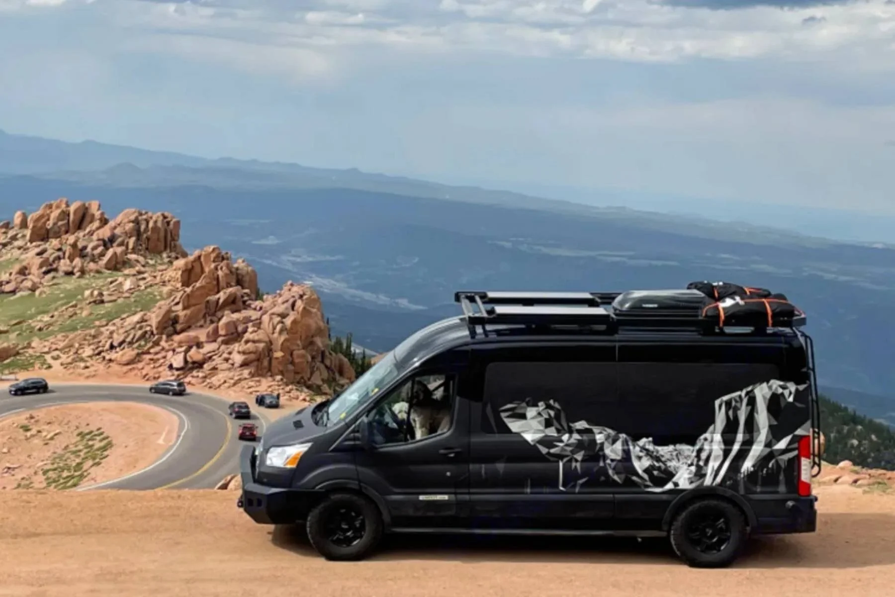 Family-friendly camper van rental in Kansas, featuring a black camper van parked at a scenic overlook with ample space for family road trips and adventures.