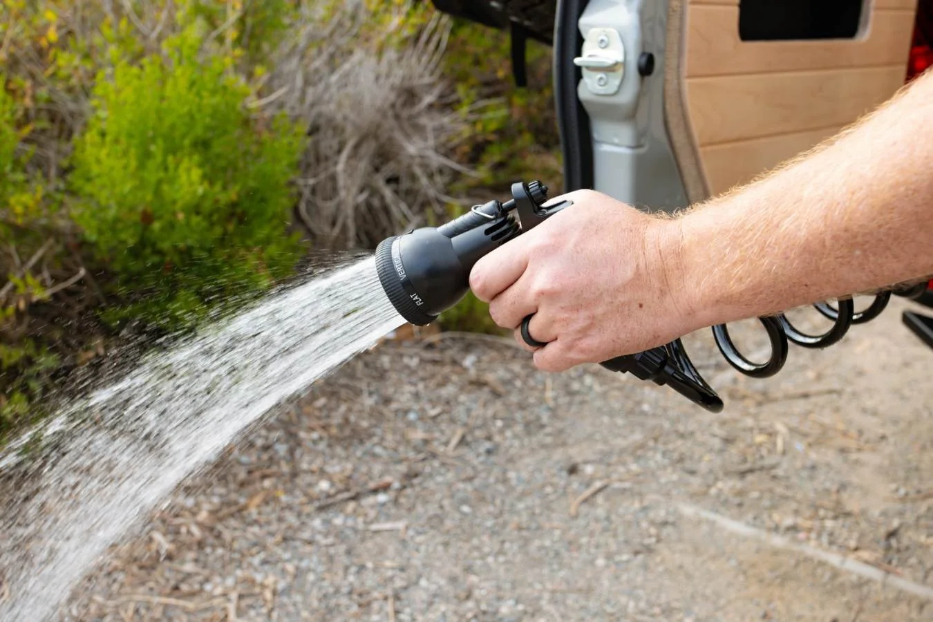 Exterior hot shower port on luxury Sprinter camper van conversion.