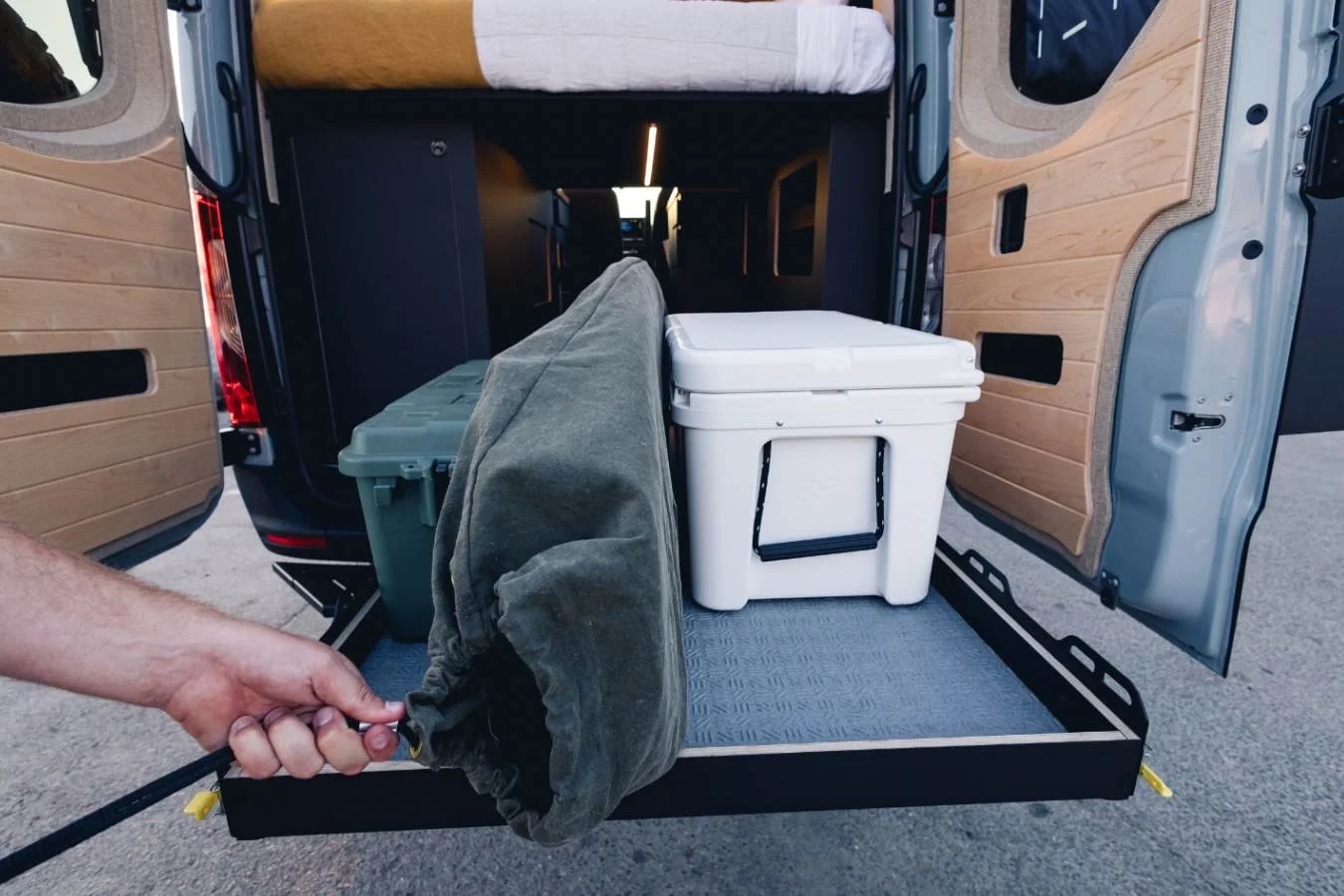 Rear gear drawer with cooler and storage in camper van.