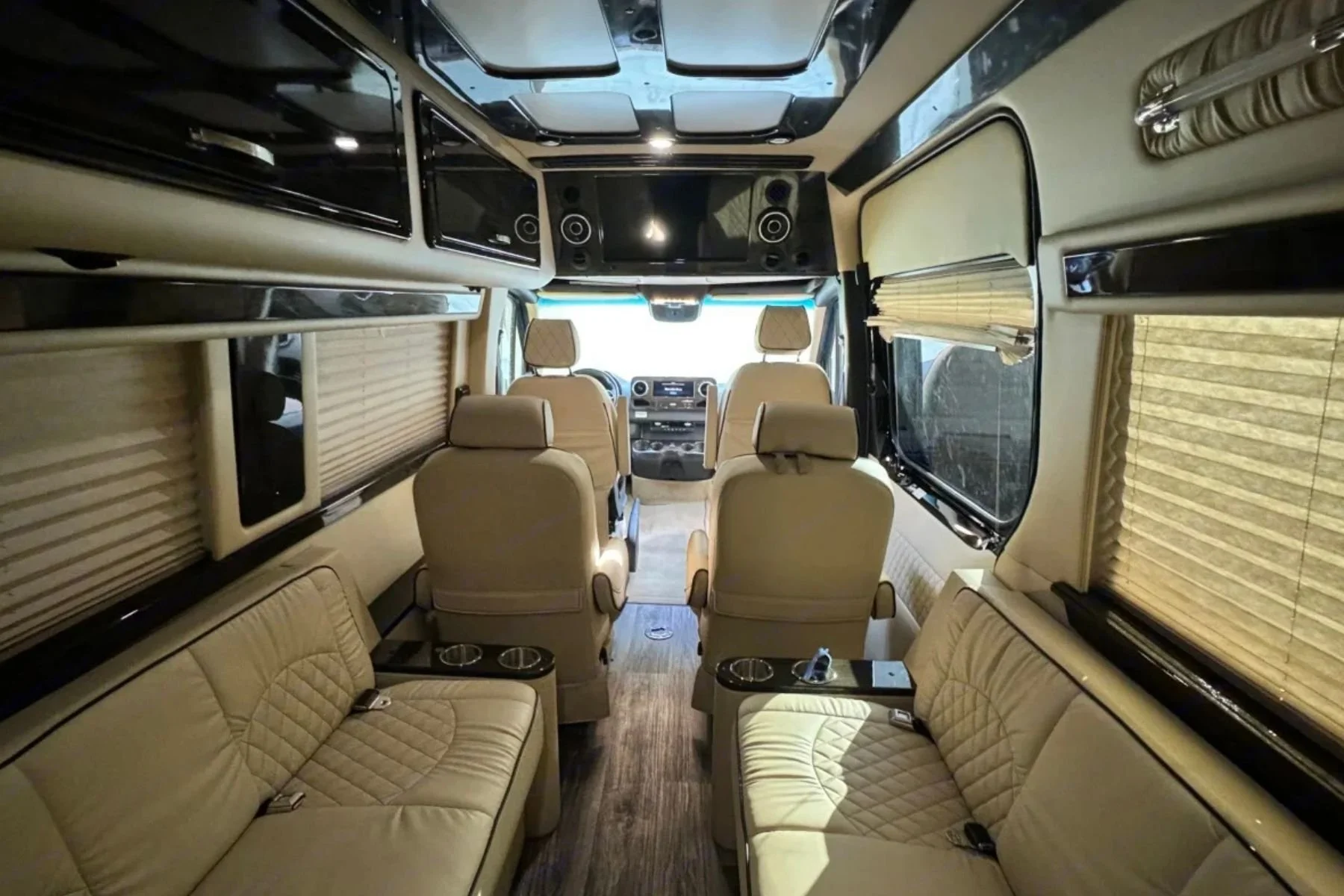 Best Class B RV for groups in Virginia, luxury Mercedes-based cruiser interior with seating for 10 passengers, premium leather seats, overhead entertainment, full kitchen, hot shower, and onboard toilet.