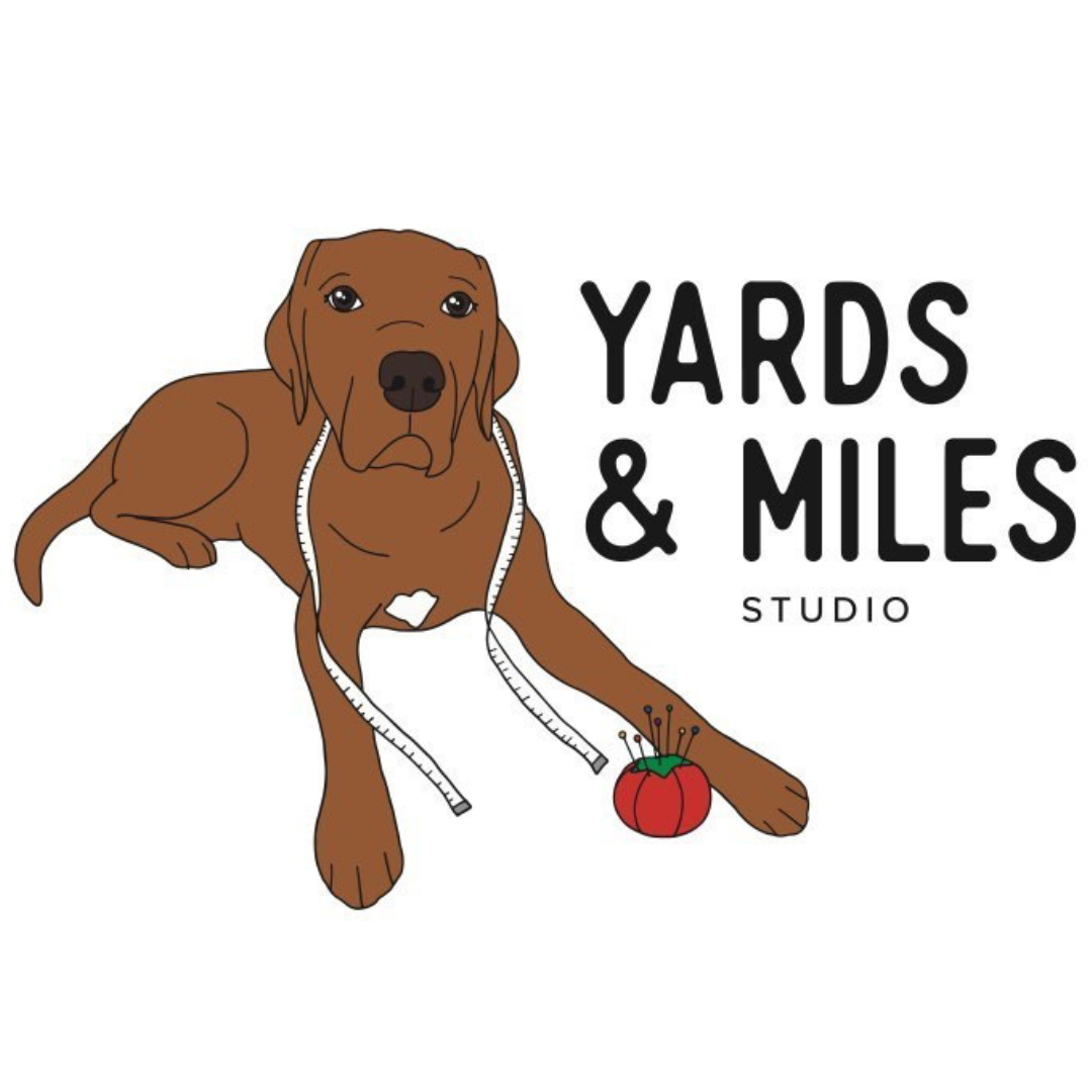 Illustration of a brown dog lying down with a white measuring tape around its neck. There's a red tomato-shaped pincushion beside its paw. The text "Yards & Miles Studio" is displayed next to the dog.