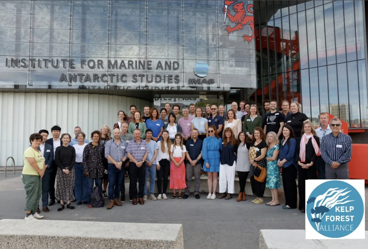 Group of people posing in front of the Institute for Marine and Antarctic Studies building, with a sign for Kelp Forest Alliance.