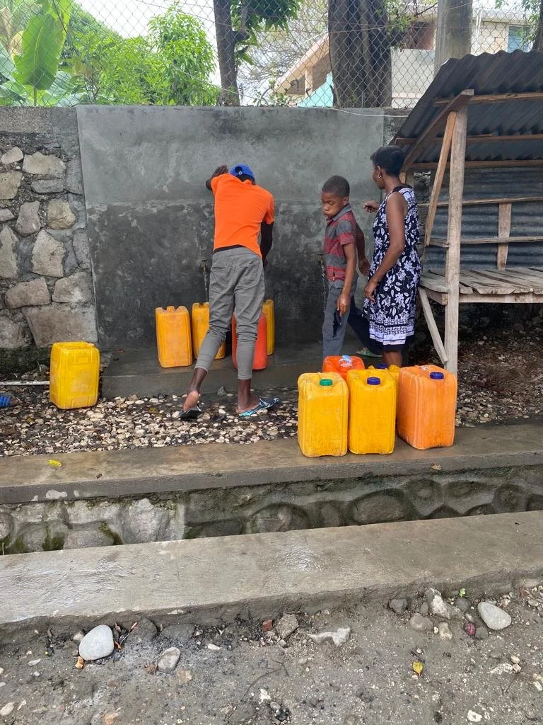 Locals filling up water jugs for distribution