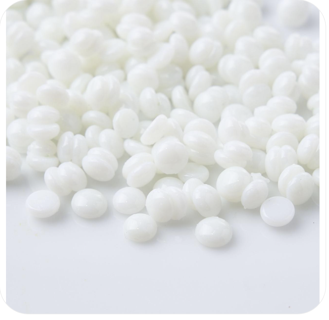 Close-up of white, shiny, round beads scattered on a white surface.
