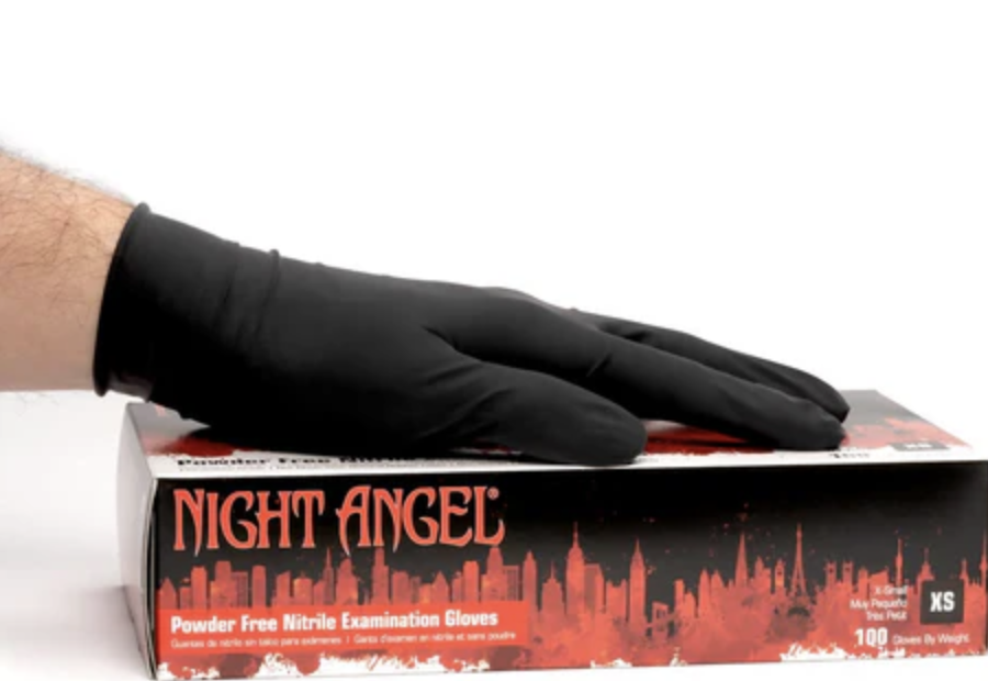 Hand in black glove resting on a box labeled 'Night Angel' powders free nitrile examination gloves against a white background.