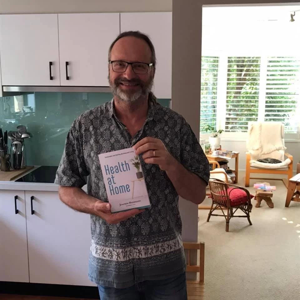 Joachim Herrmann holding his book, Health at Home.