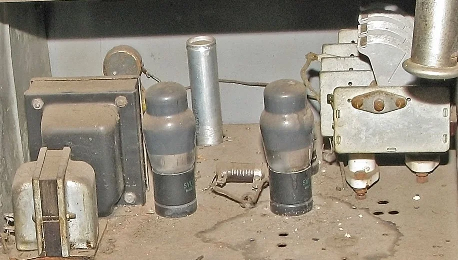 "Low" device circuitry closeup, upper level right. Light grey condenser (capacitor) on far right connects to audio oscillator dial at front of device.