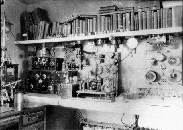 #3 ray device on workbench, wide view. Shows edge of #3 microscope and Piffard tube at far left. Kennedy radio is at left back corner of bench. Dated 1933 or later.