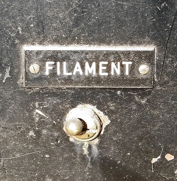 "Low" device closeup of filament switch, near lower left corner of cabinet front.