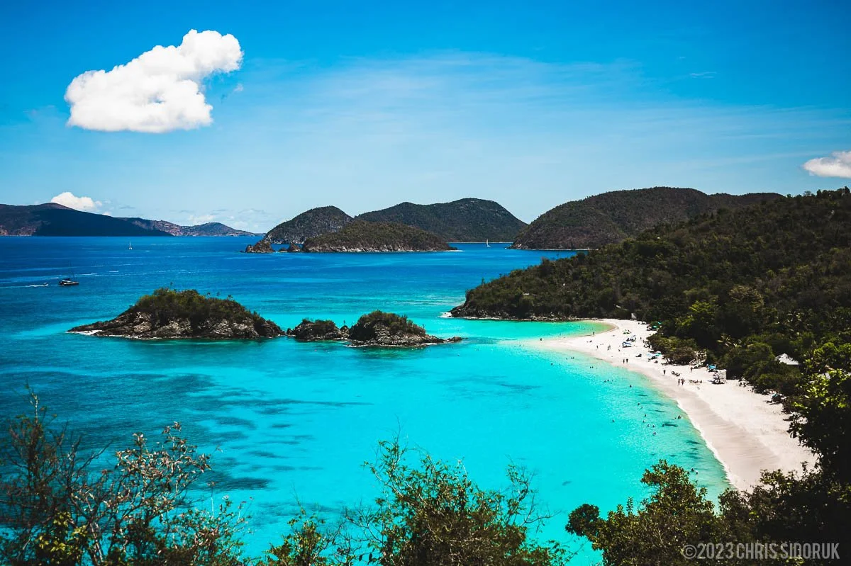St John USVI Trunk Bay overlook with turquoise water, white sand beach, and surrounding Caribbean islands