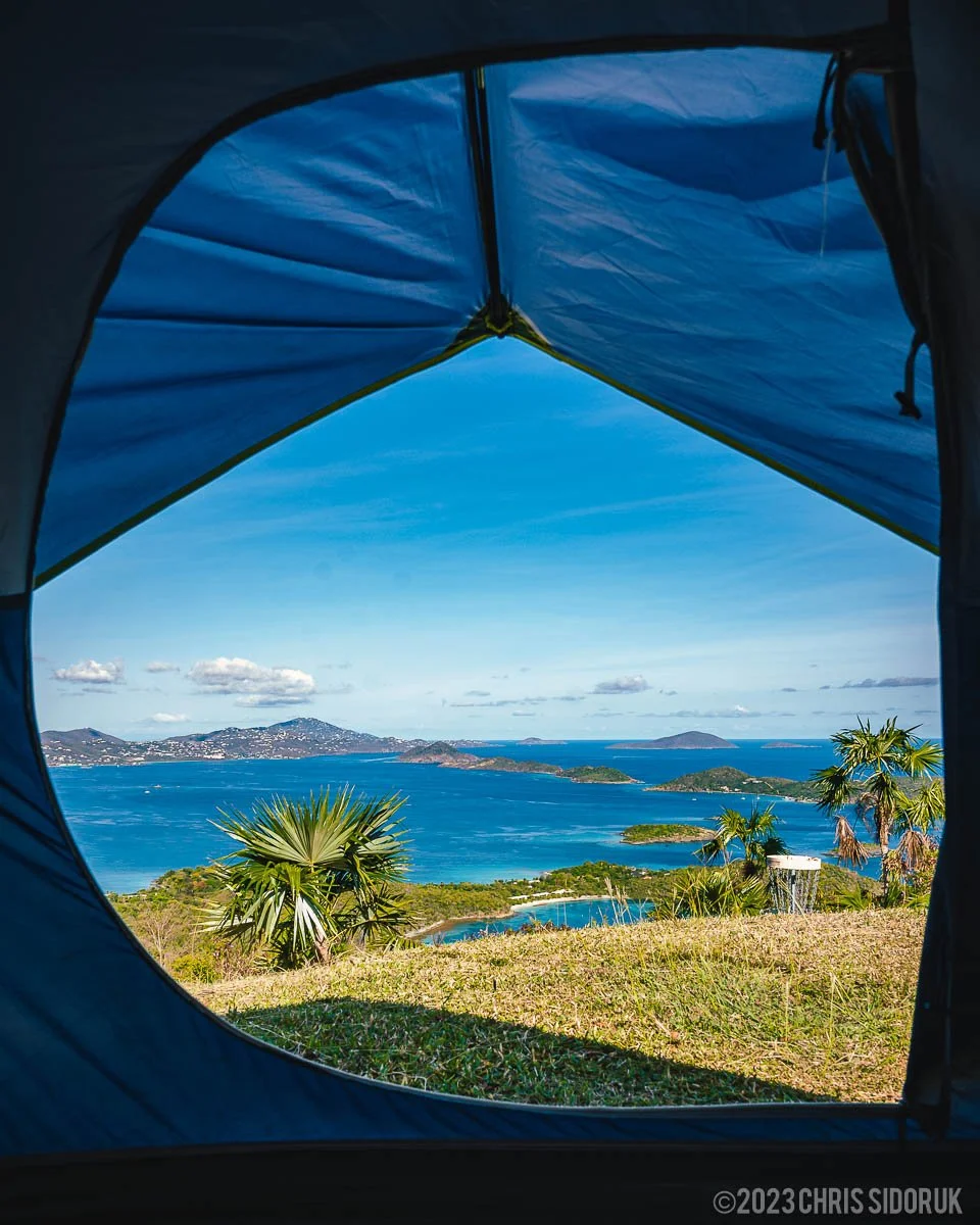 View from inside a tent in St John USVI overlooking ocean and surrounding islands under blue sky