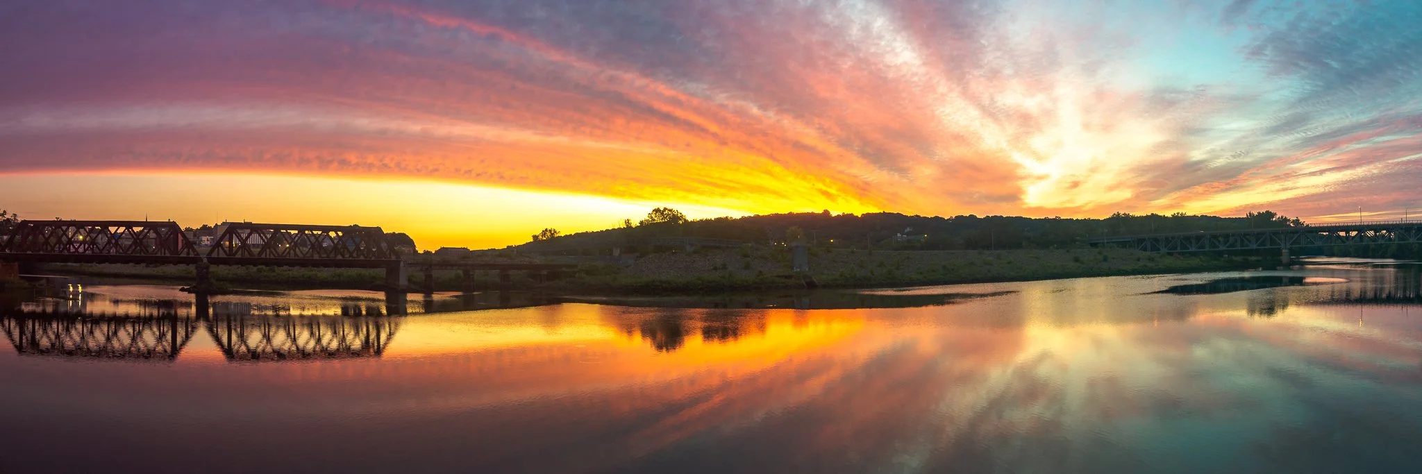Stunning panoramic image of a sunrise over the Housatonic River in Shelton, Connecticut, with vibrant colors and reflections on the water.