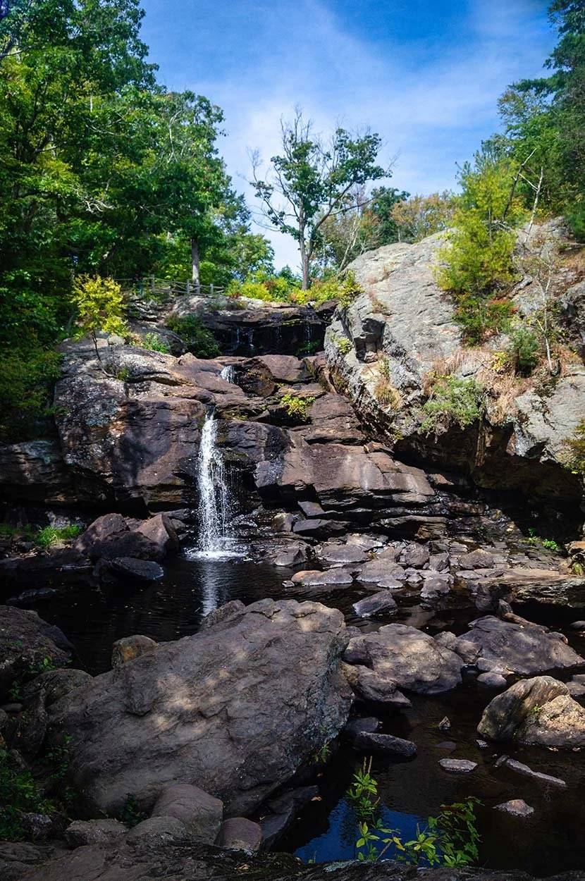 Chapman Falls, a multi-tiered cascade of water surrounded by lush foliage at Devil's Hopyard State Park.