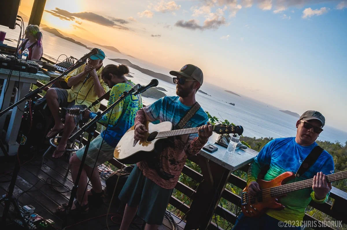 Live band performance in St John USVI overlooking the ocean with musicians playing at sunset