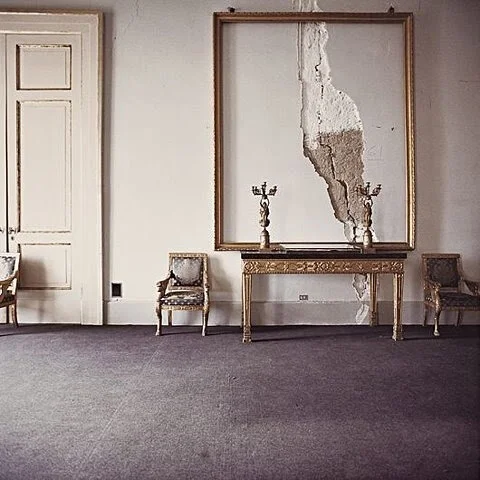 Elegant room with cracked wall and ornate frame