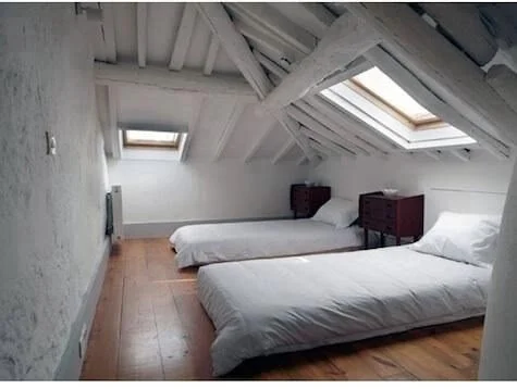 Attic bedroom with two single beds and skylight windows