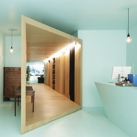 Modern interior with a geometric wooden cube structure, desks, and pendant lights.