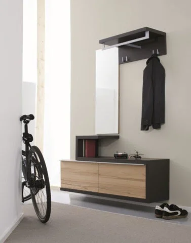 Modern entryway with wall-mounted coat rack, mirror, wooden cabinet, bicycle, and shoes on the floor.