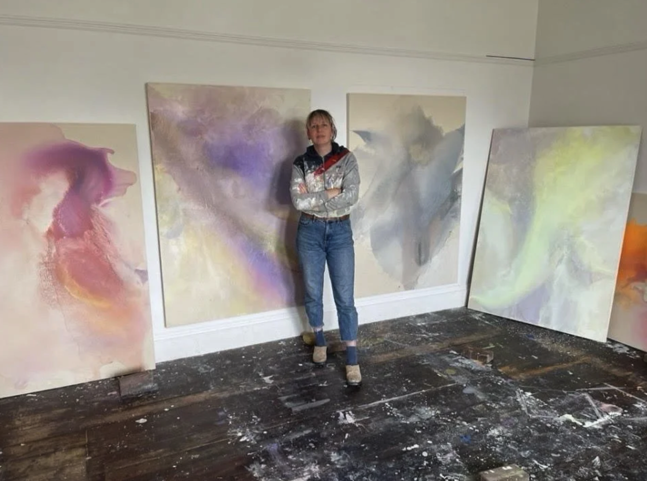 Artist standing in front of paintings