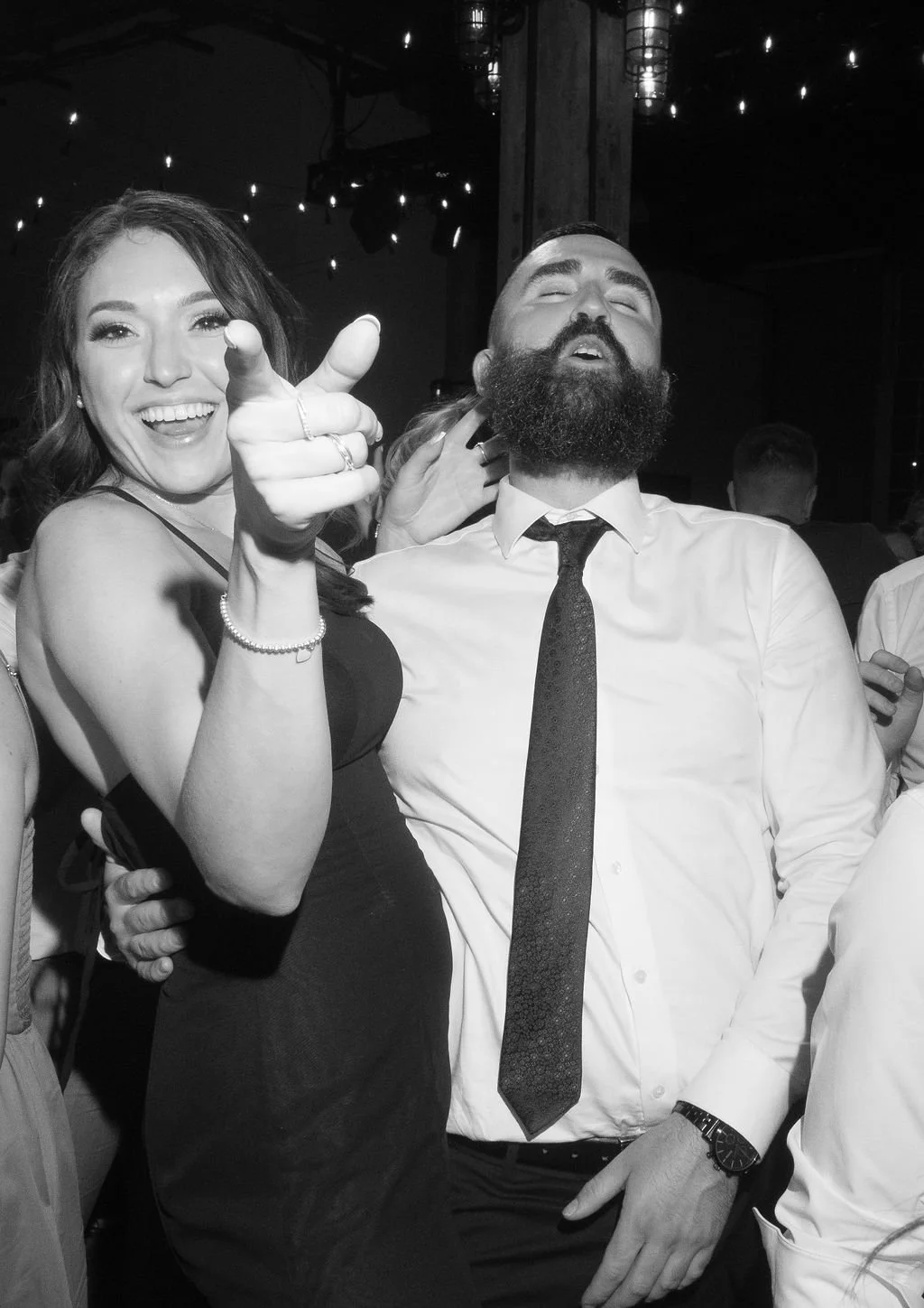 Candid Wedding Party shot of a female guest pointing at the photographer