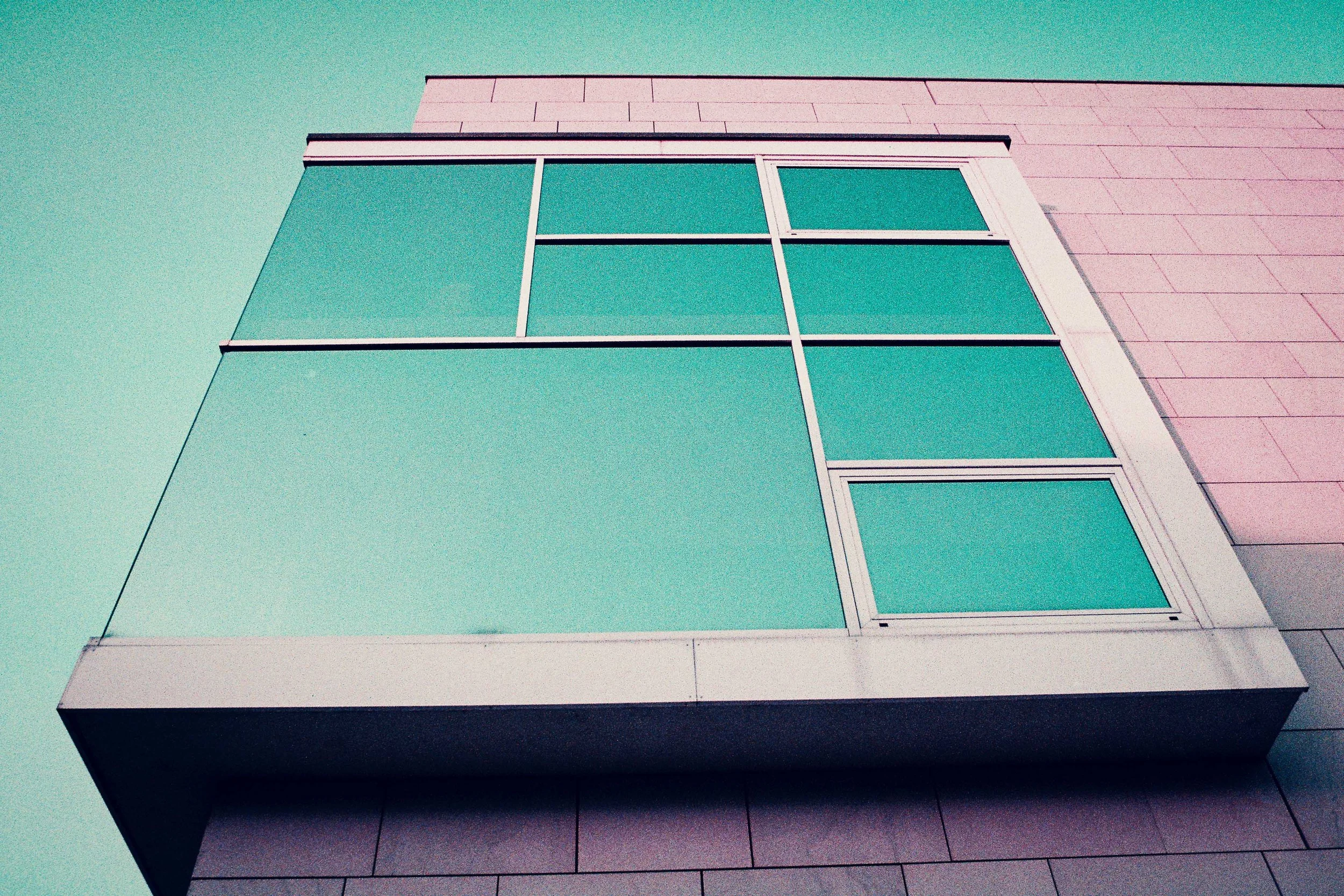 Facciata di edificio moderno con vetrata sporgente fotografata con LomoChrome Purple Lomography