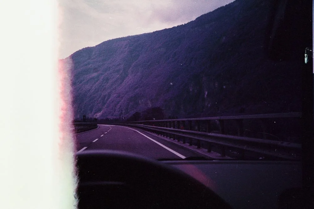 Vista di una strada interstatale con montagne sullo sfondo e una fotografia con effetto vintage.