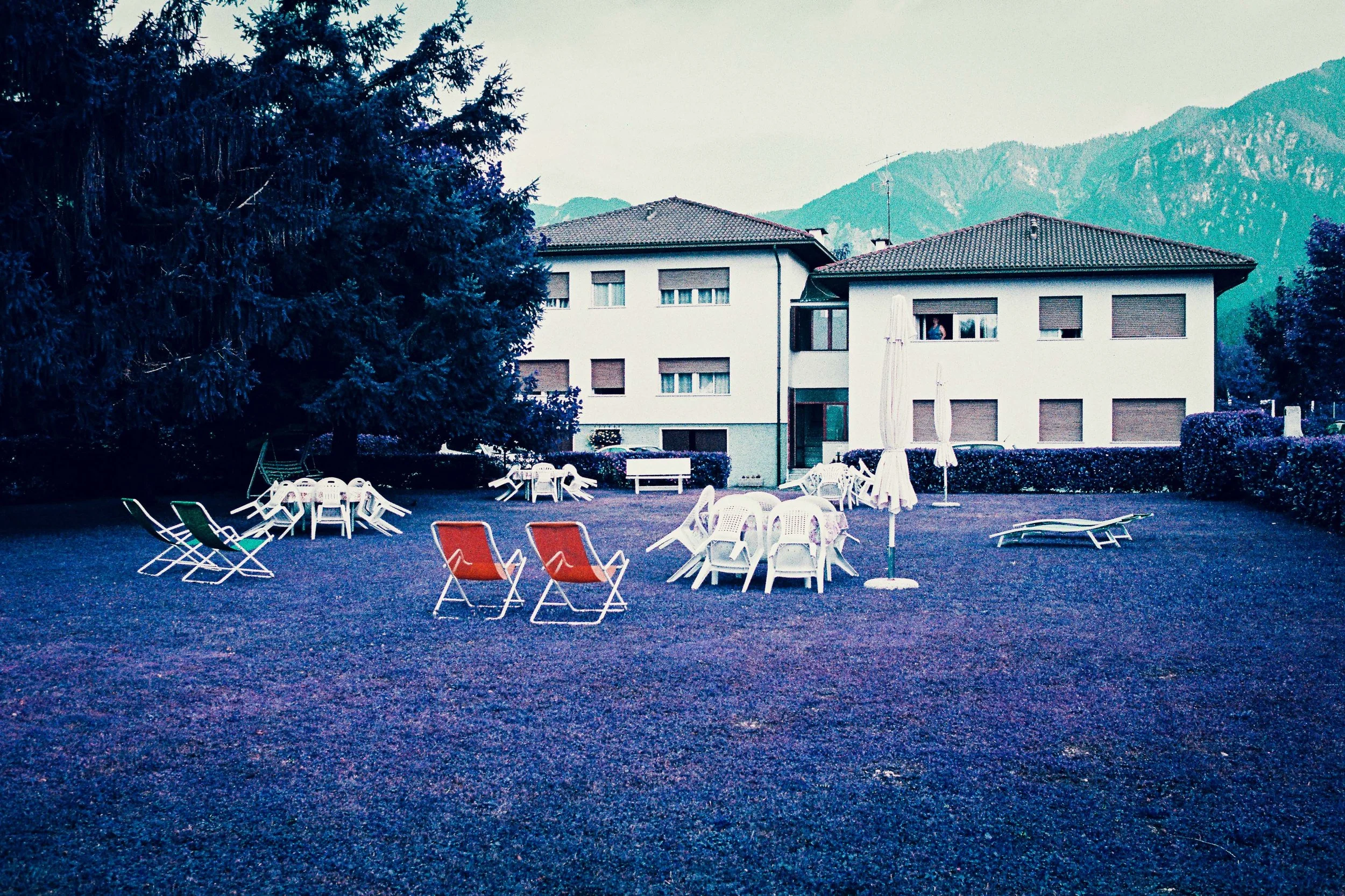Giardino con sdraio arancioni e prato viola fotografato con LomoChrome Purple Lomography, Caldonazzo
