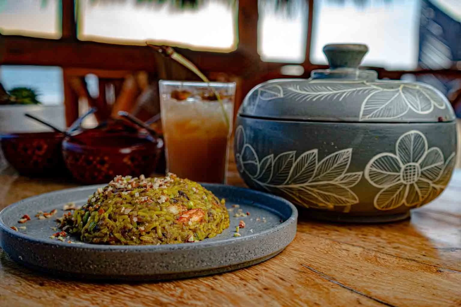 Plato de arroz con verduras y frutos secos, acompañada de una bebida fría, en un ambiente rústico baxar pie de la cuesta
