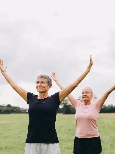 Two women, arms out stretched.