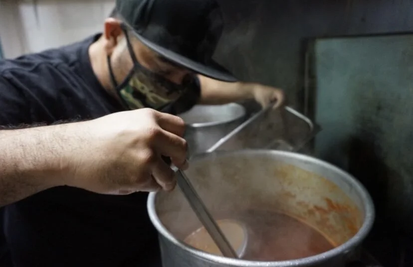 Lenny cooking hot sauce in a pot