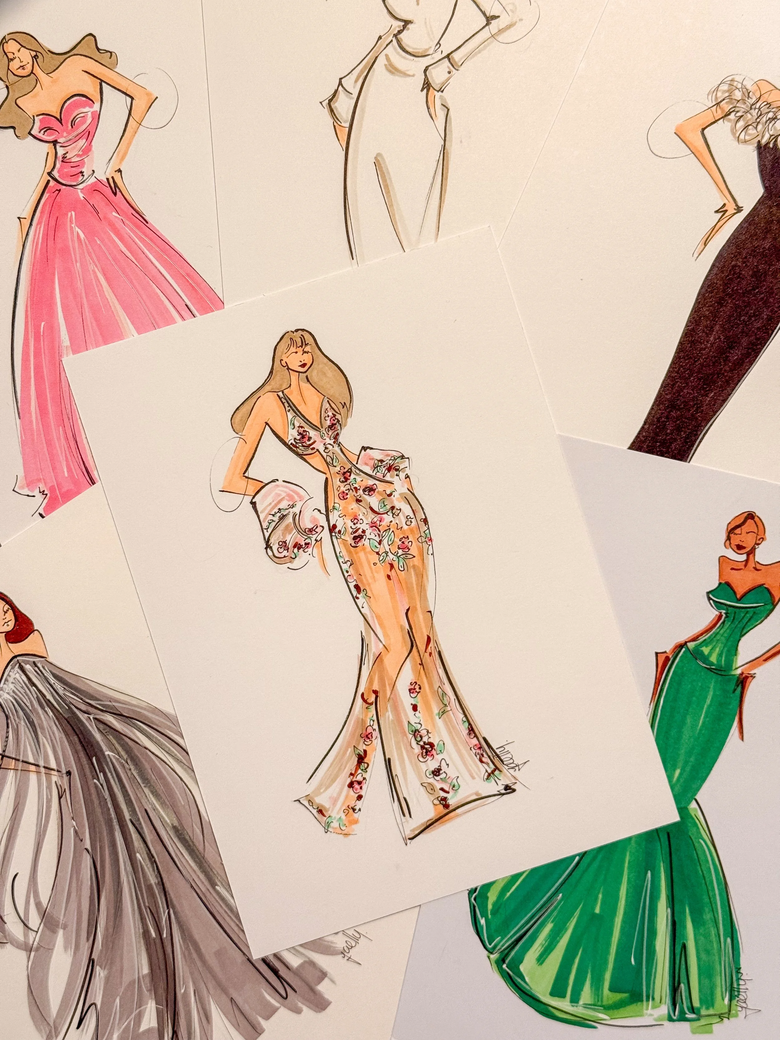 Collection of fashion illustrations of women in elegant dresses, featuring various styles and colours, including pink, black, green, and floral designs.