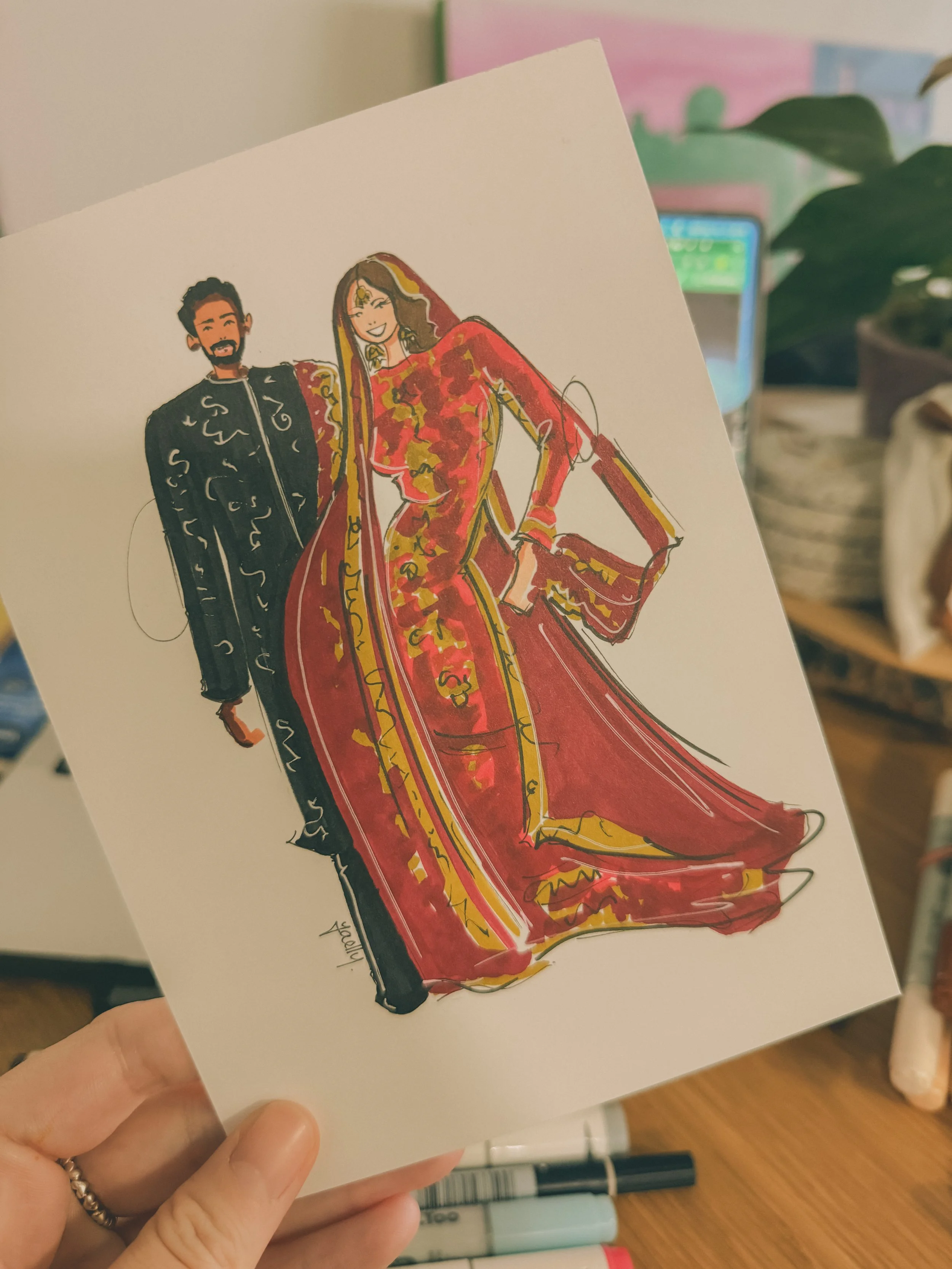 A colourful illustration of a man and woman dressed in traditional Indian attire, with the woman wearing a red and gold sari and the man in a black kurta. The woman is smiling and holding a matching purse.