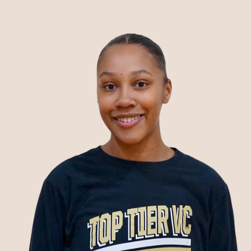 A young woman smiling, wearing a black T-shirt with gold and white text that reads "TOP TIER VC."