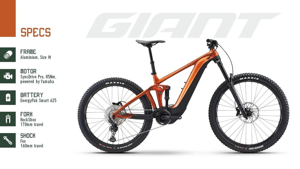A mountain electric bike with specifications listed on the side, including aluminum frame, Yamaha powered motor, EnergyPak battery, RockShox fork, and Fox shock.